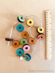 Rainbow Threading Beads: Colourful wooden beads for threading and sensory play, designed to encourage fine motor skills and creativity.