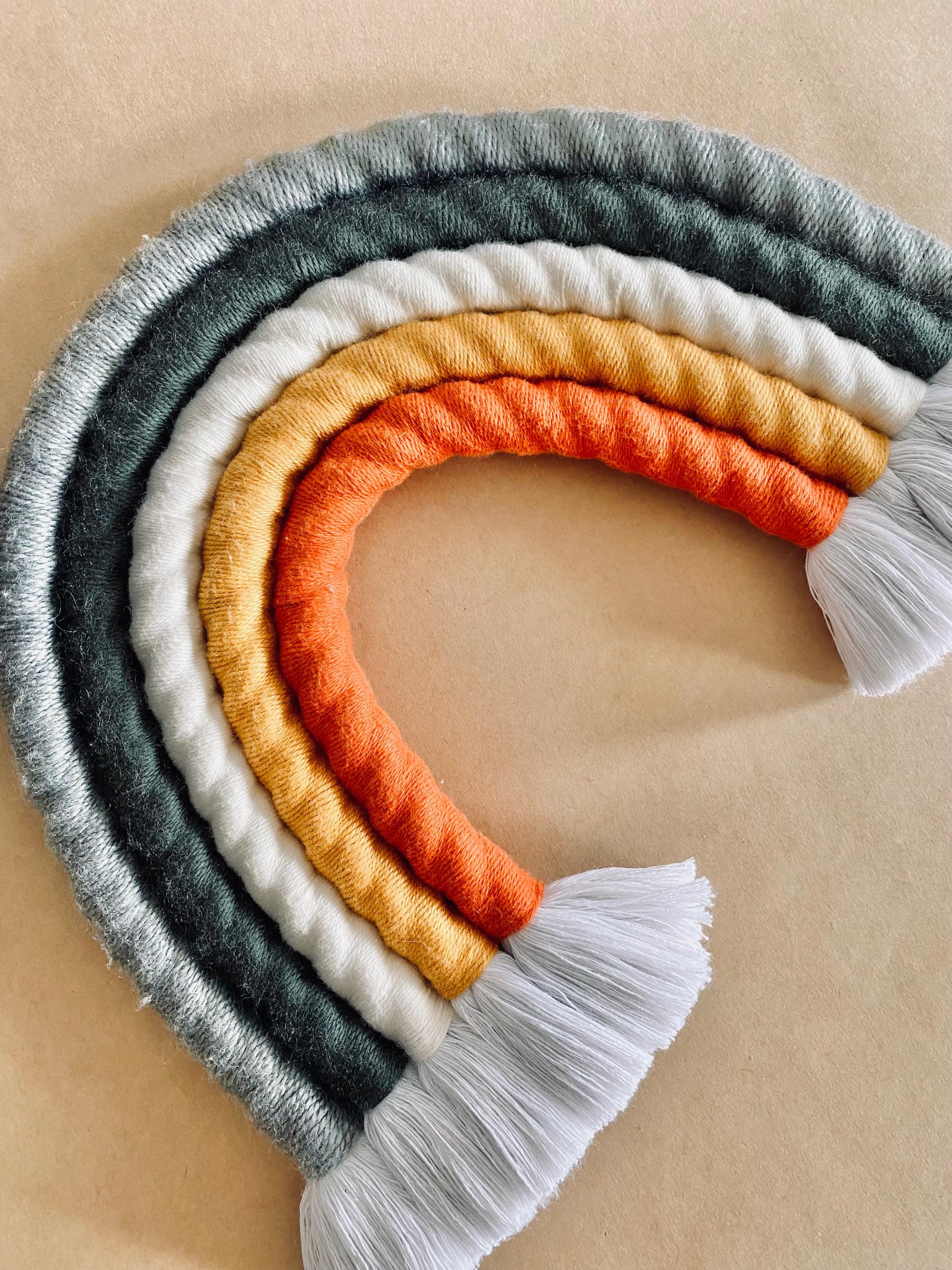 Chunky macrame boho rainbow wall hanging, ideal for brightening up a nursery or adding vibrant decor to any space.