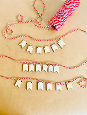 Miniature Wooden Garland with Twine: Small wooden garland with red and white twine for dollhouses or fairy gardens.