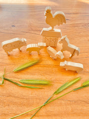 Unpainted birchwood farm animal set, an 8-piece Montessori toy perfect for creative play and crafting.