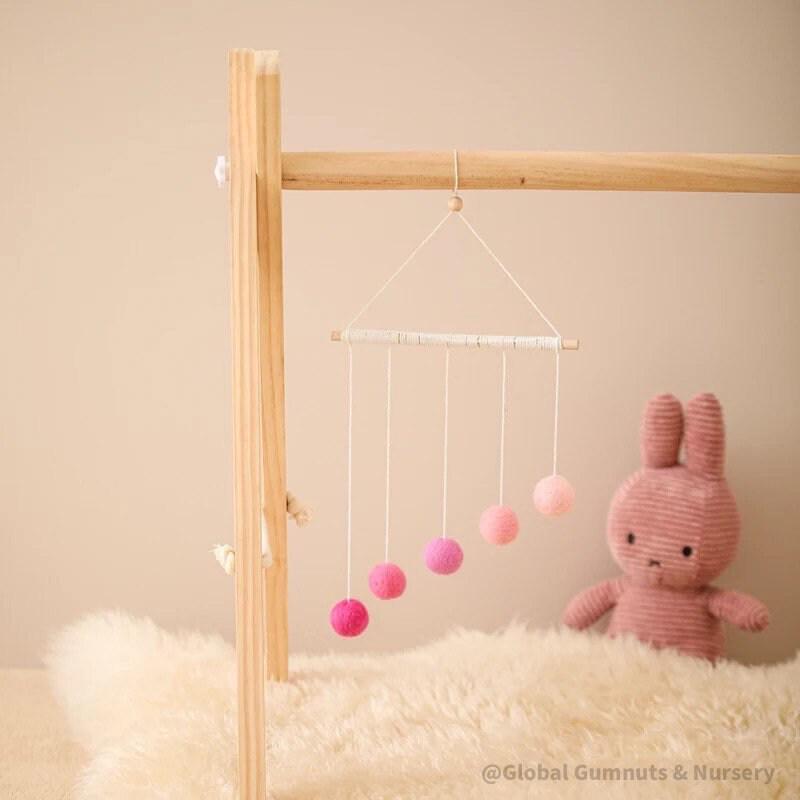Montessori-inspired color bar baby mobile in pink, an eco-friendly and soothing nursery decor.
